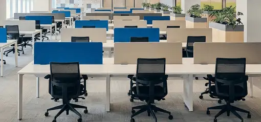 Modern open-plan office space featuring clean workstations, ergonomic chairs, and sanitized carpets provided by professional office cleaning services in Dover, DE.